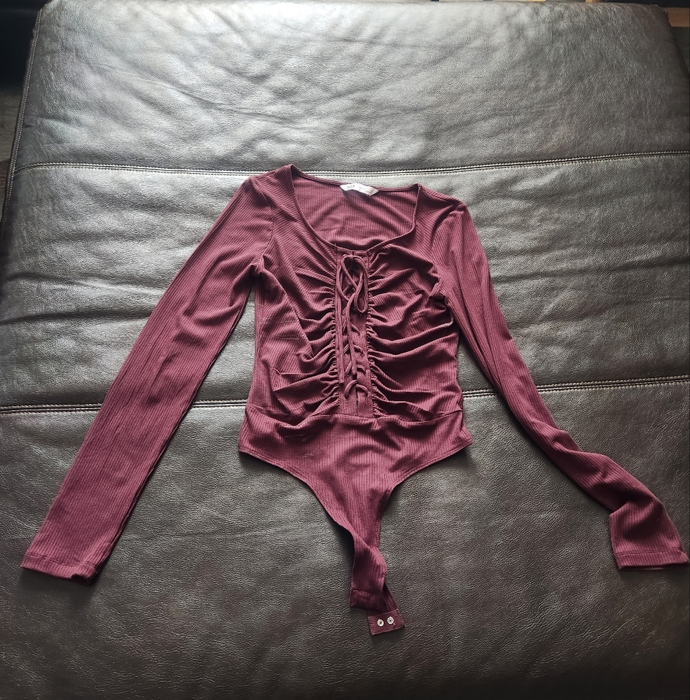 A burgundy body suit